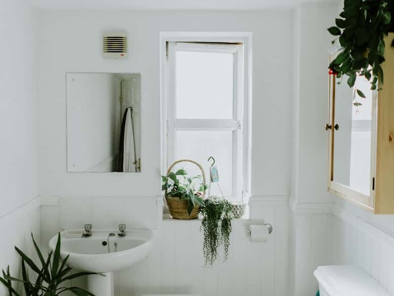 Baño reformado por Vega Home en Sevilla con plato de ducha, mampara de vidrio y mueble lavabo
